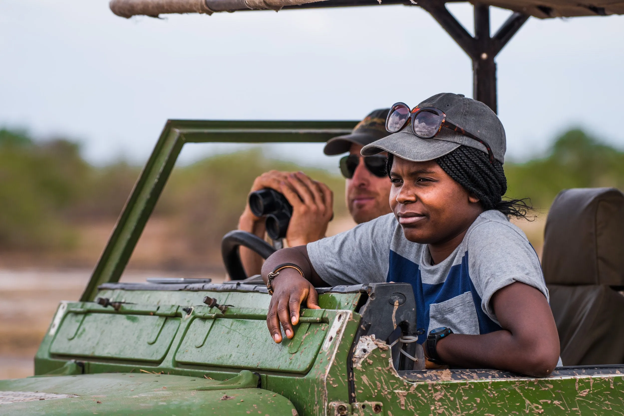 Scientists Thandiwe Mweetwa and Matt Becker looking at a pride of lions in South Luangwa National Park.