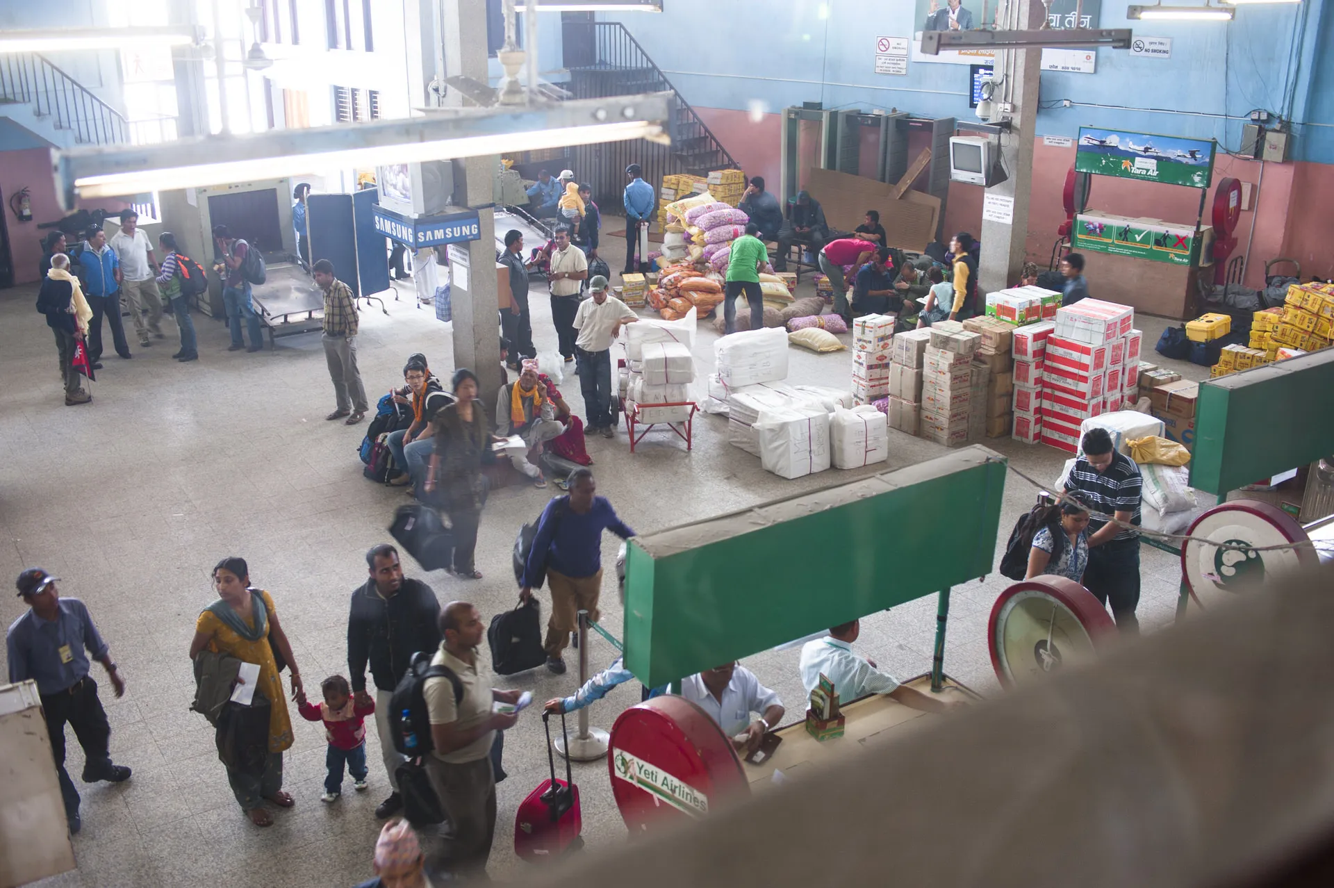 Looking down on the cargo and passenger area of Tribhuvan Airport in Kathmandu, palettes of supplies stacked for flights up to the mountains.