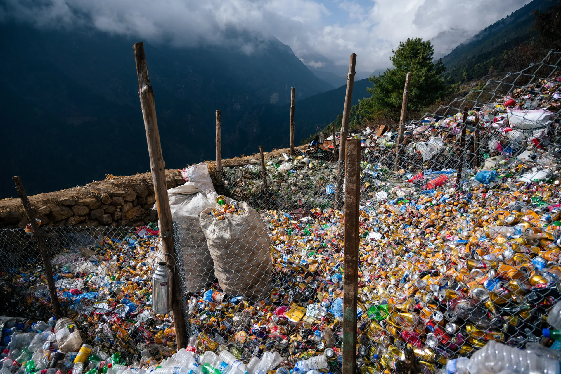 A fenced-in waste sorting dump above Namche Bazaar packed with plastic bottles and cans, gathered for haul-out by the SPCC.