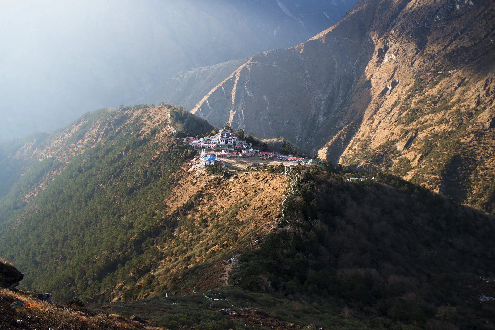 Tengboche monastery sits high on a forested ridge above the Khumbu valley, the gorge of the Dudh Kosi river dropping away beside it.