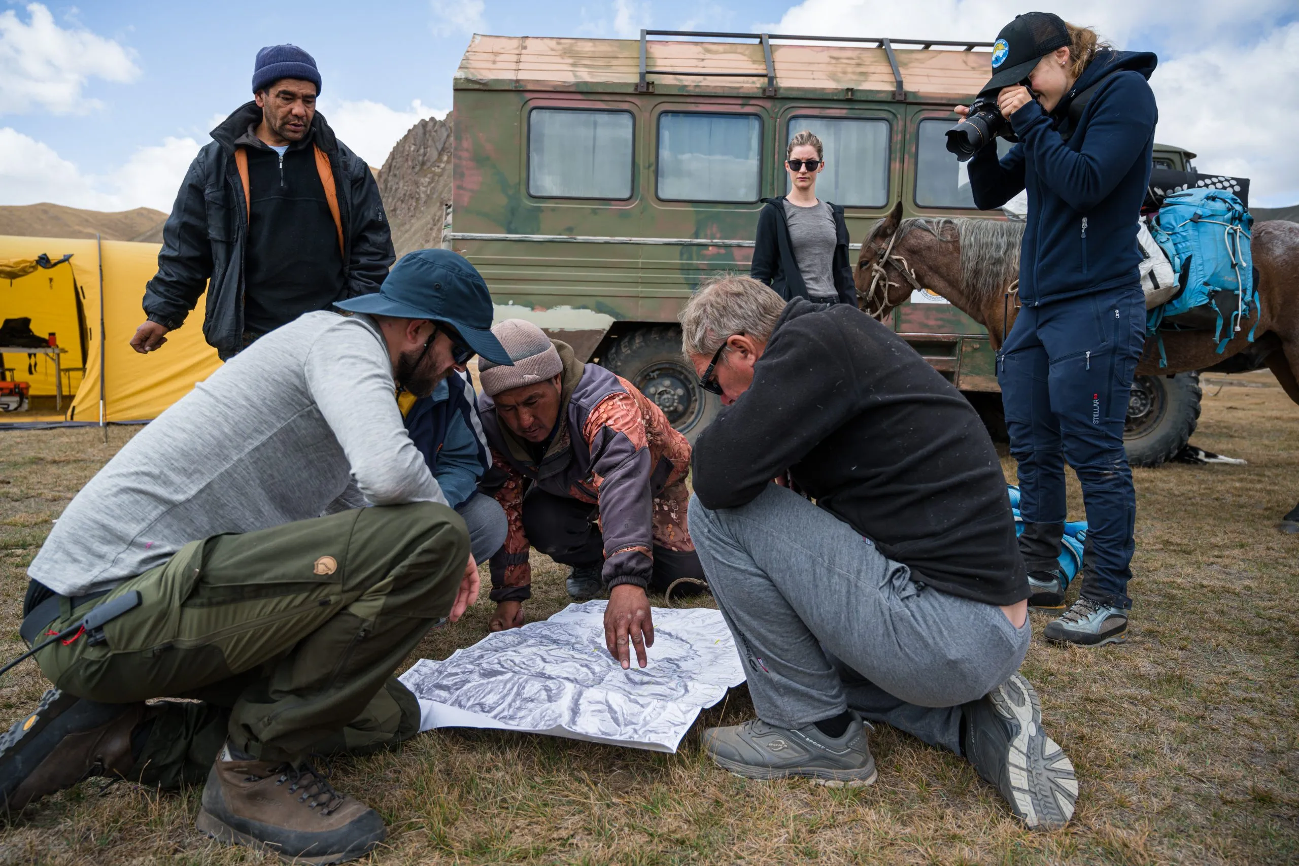 The expedition team looking at a preliminary map of the area, built on satellite data and markings from Soviet-era maps and expedition data.
