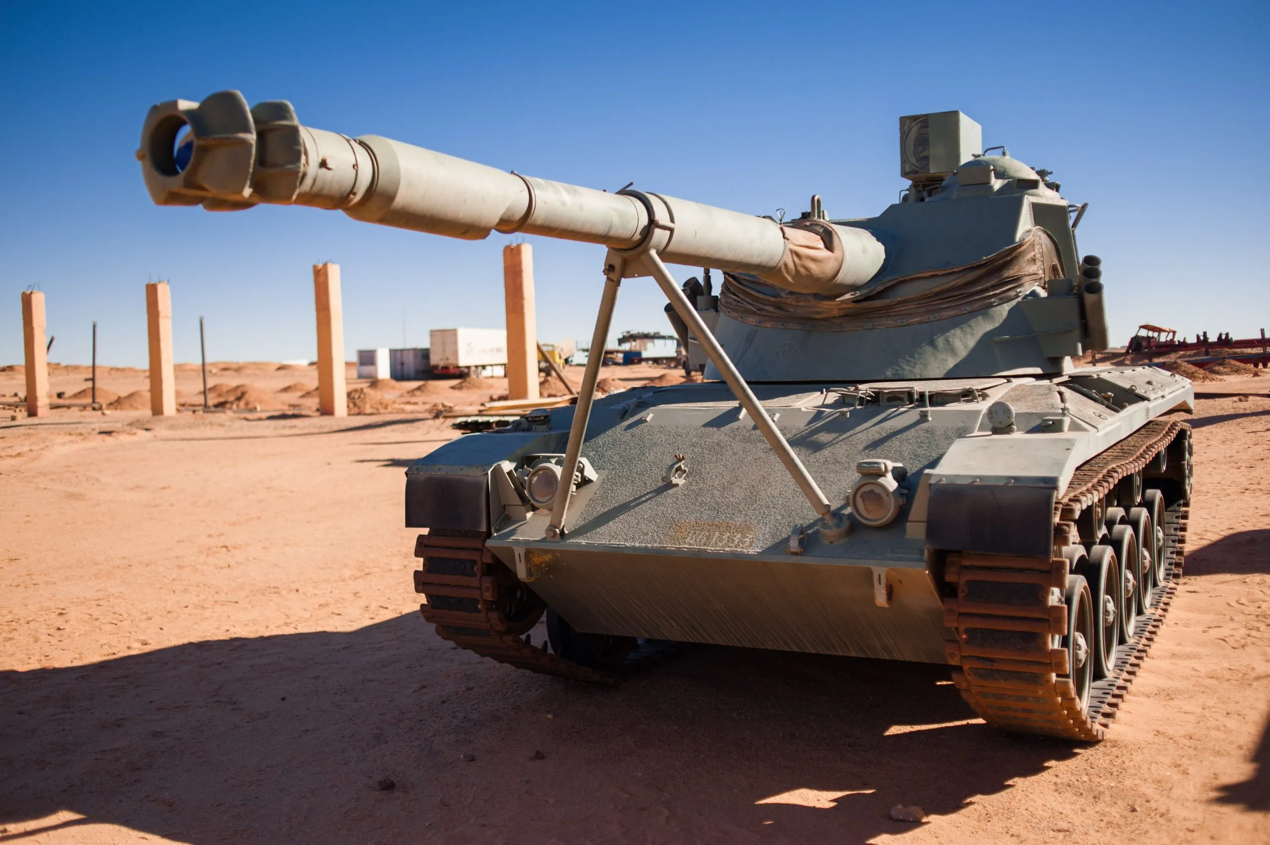 An old armoured tank stands in the open desert under a wide blue sky, near the Tindouf camps in Algeria.