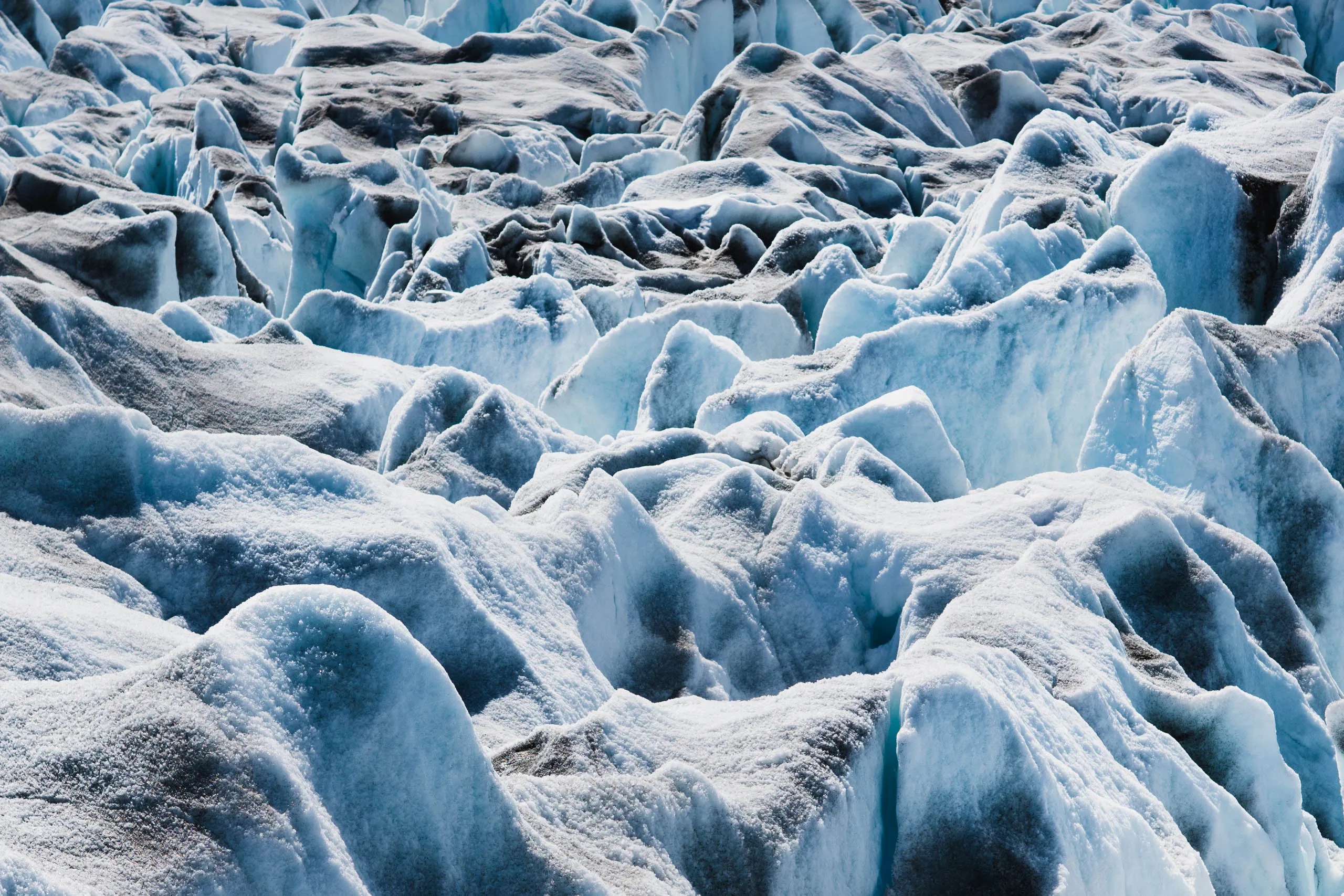 Close-up of jagged blue-white glacier ice formations filling the entire frame