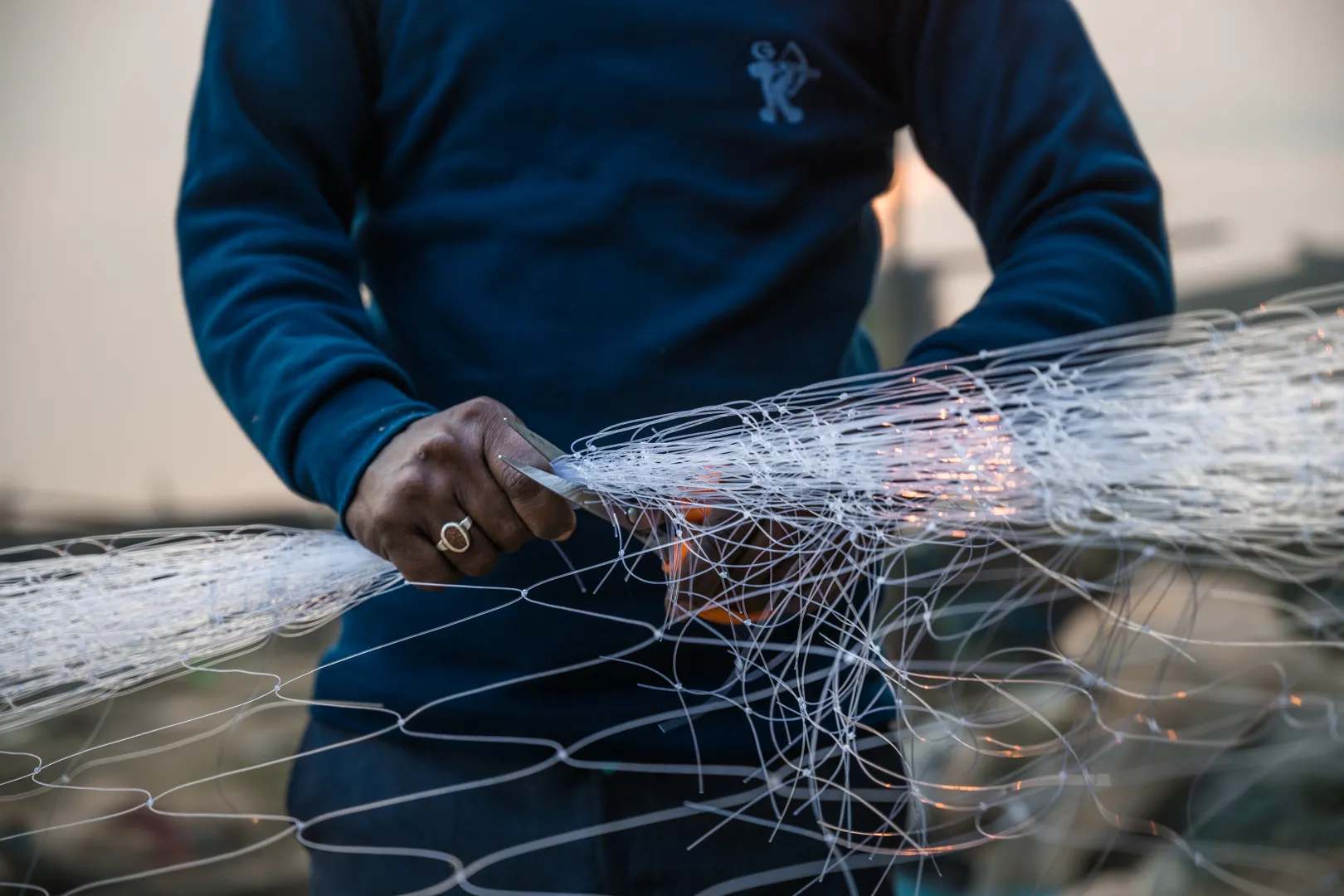 A local fisherman preparing fishing nets on the banks of the river Ganges.