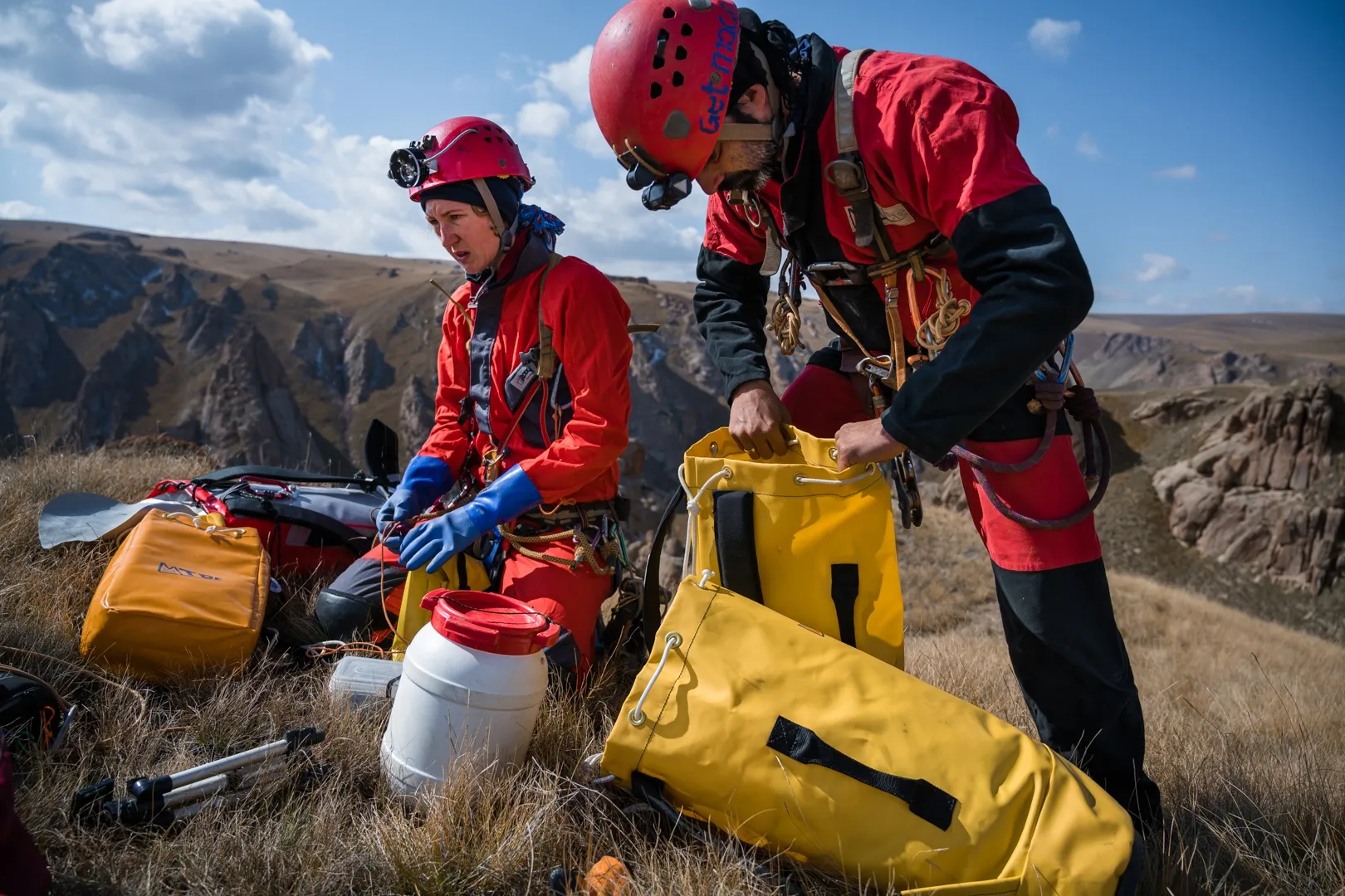 Expert cavers Yuliia Izmaylova and Carlos Sanchez preparing for a long rappel down to a possible cave opening the team found by drone.