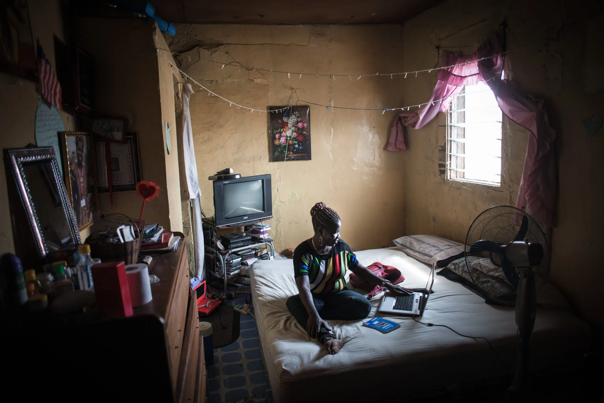 Mae Azango, Liberian journalist and activist, sitting in her bedroom.