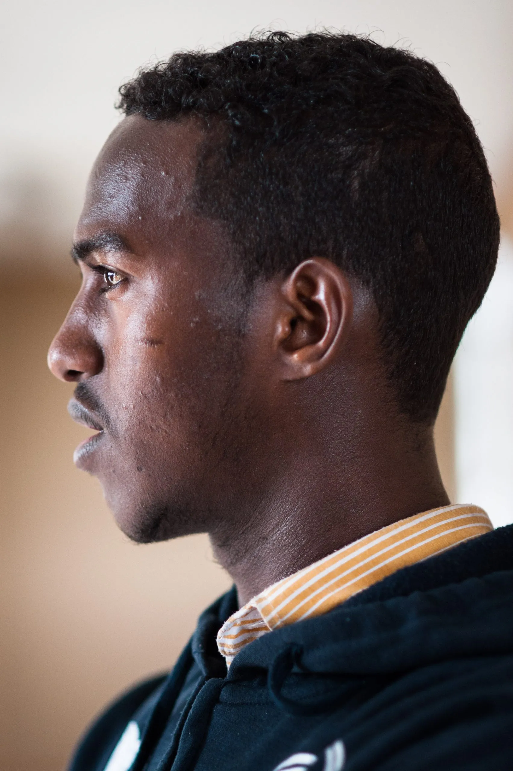 Profile portrait of a young man in soft daylight inside the housing compound on Malta.