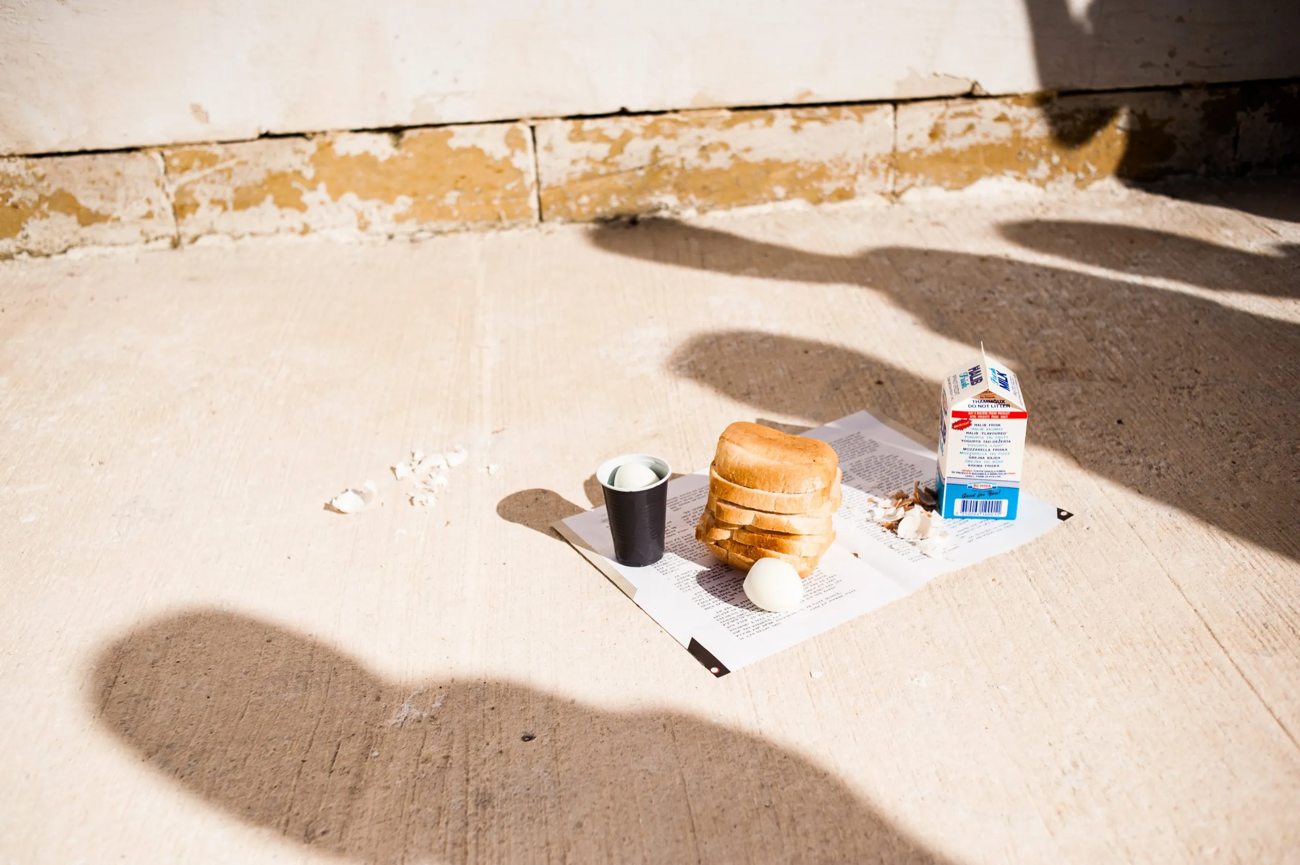 A daily food ration of bread, eggs and milk laid out on the concrete floor of the hangar housing in Malta.