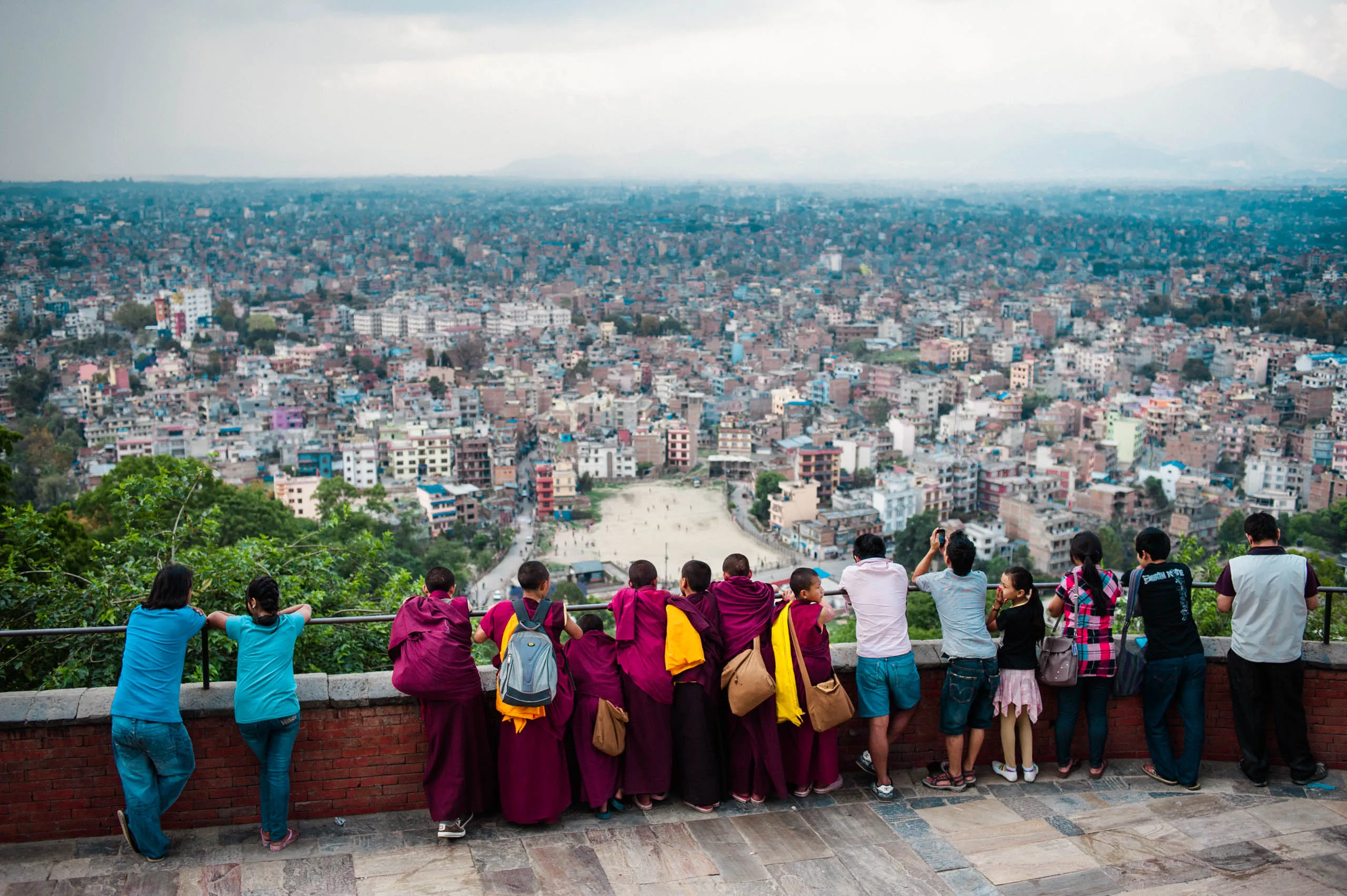Monks and visitors gaze out over the Kathmandu valley from a viewpoint at Swayambhunath temple, Nepal.