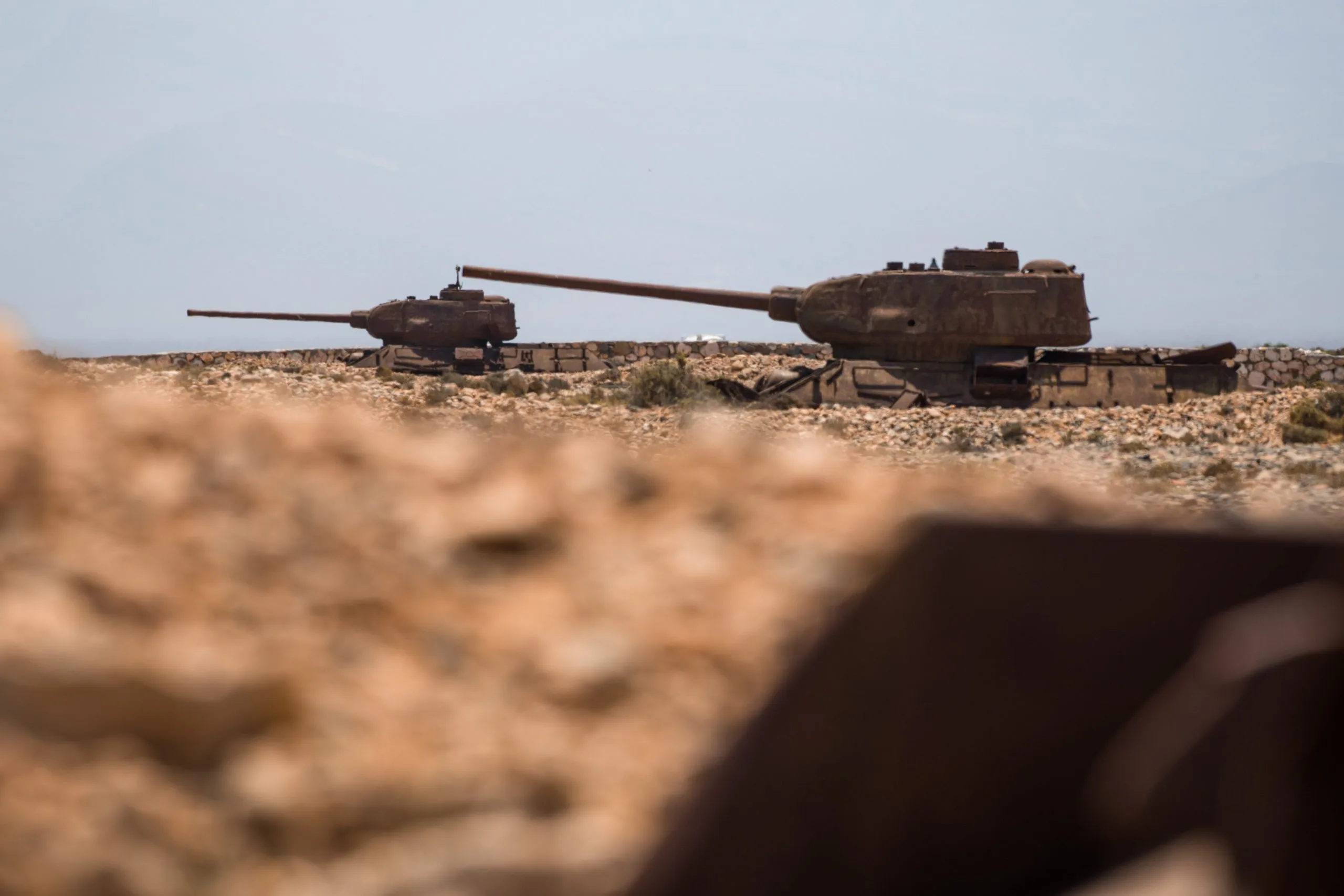 Two old Soviet-era tanks rust on a stone-walled bluff on Socotra, their long barrels pointing out across the desert.